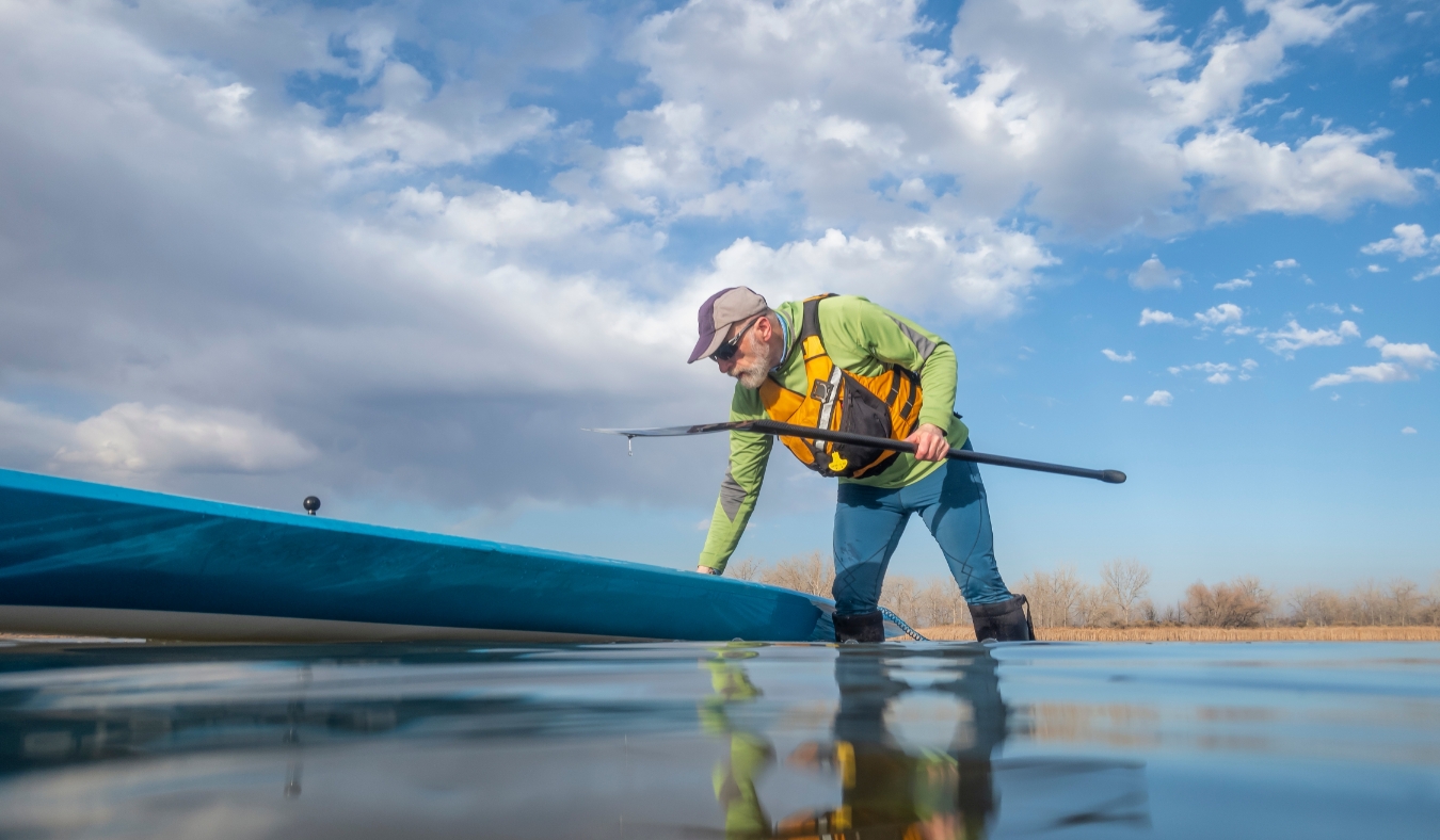 senior paddler and his paddleboard on lake