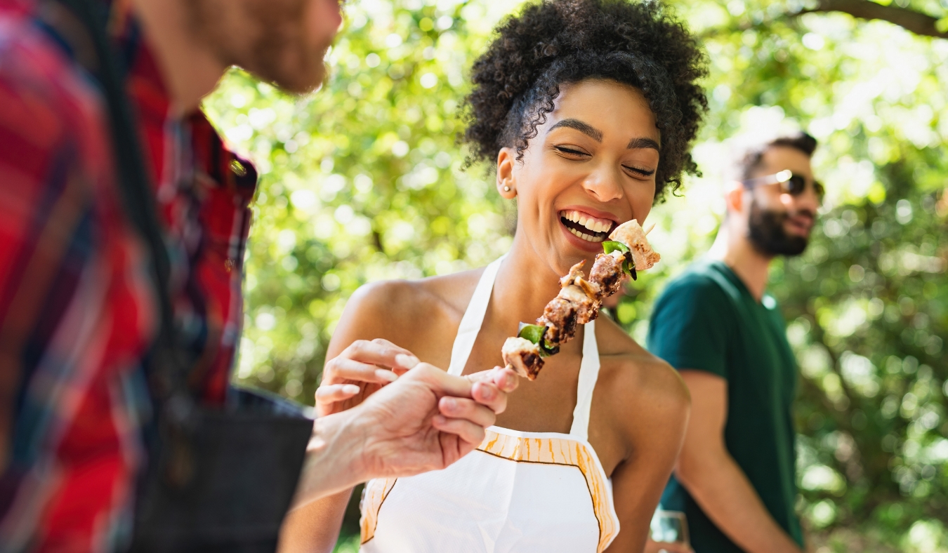 young people having fun in the park at barbecue grilling