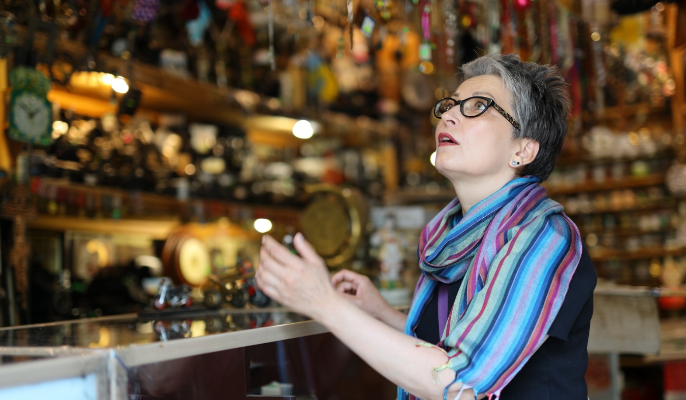 middle aged woman admiring antique shop