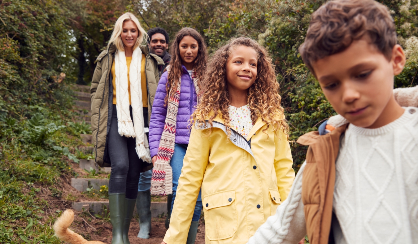 multicultural family walking downs steps in autumn countryside