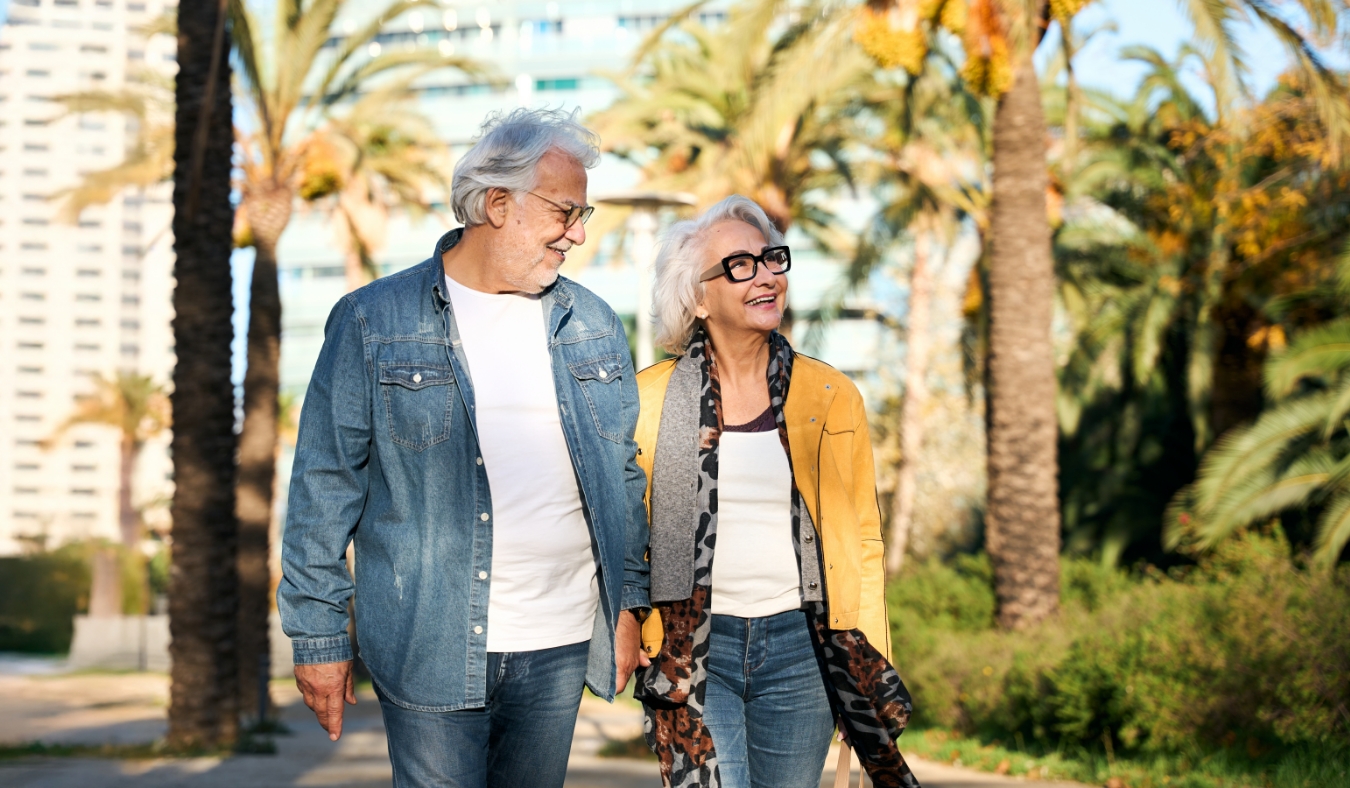 senior couple walking in tropical city during autumn