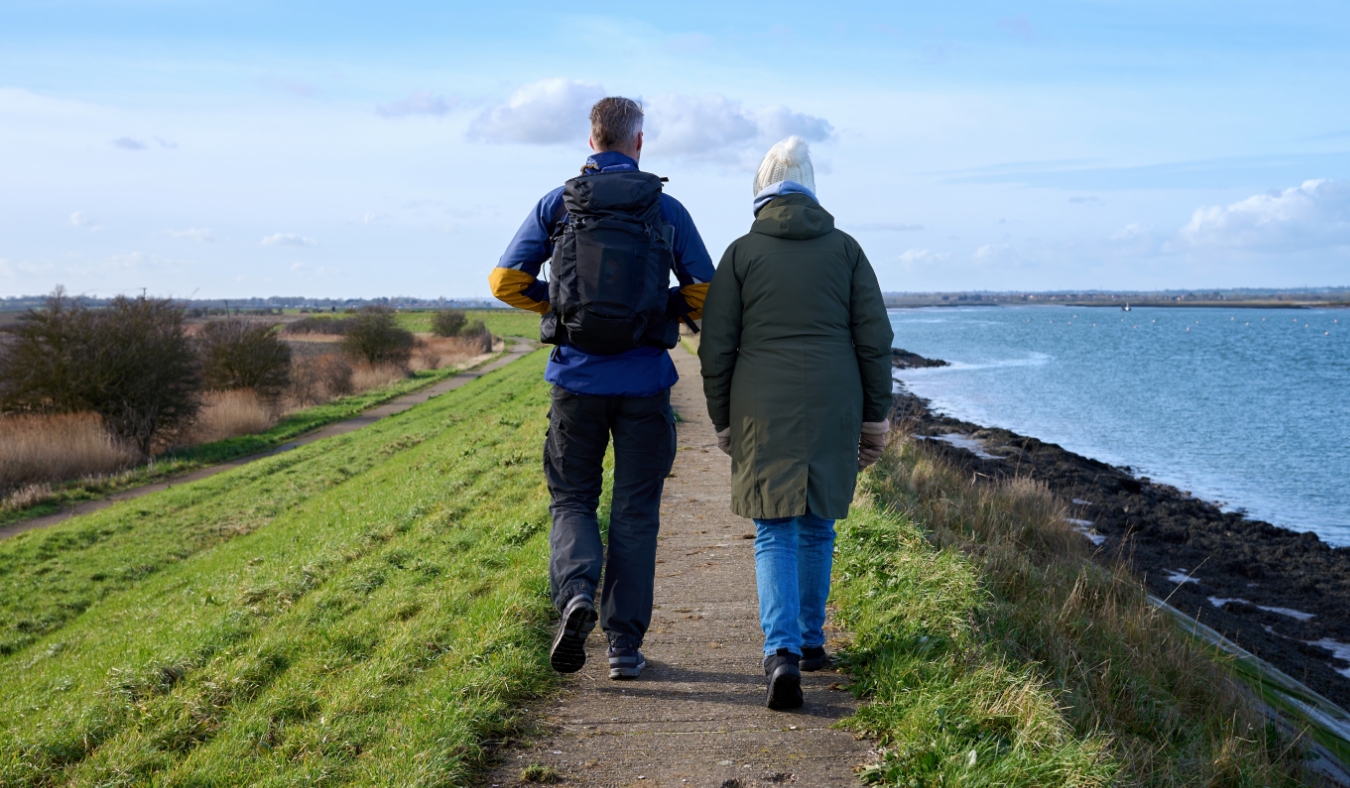senior mother and adult son enjoy chilly morning walk along shoreline