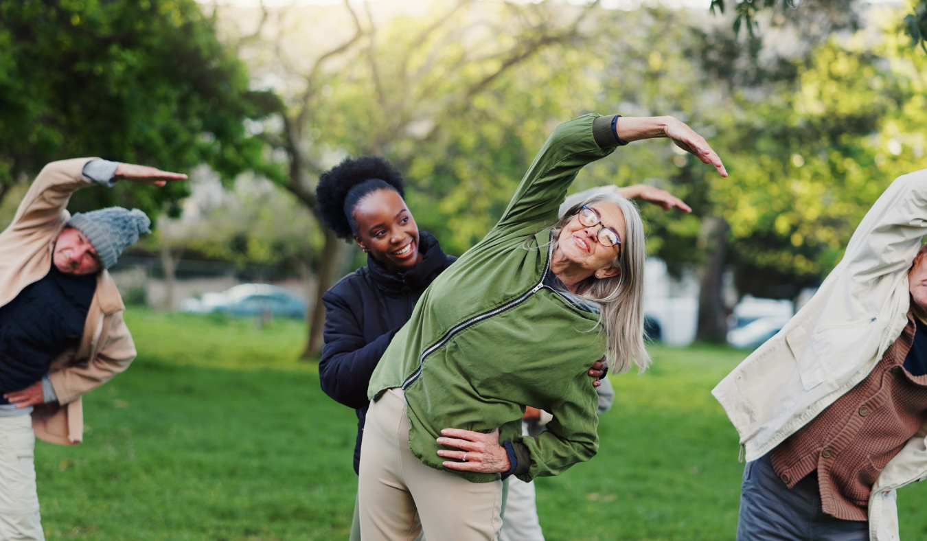 seniors doing yoga on chilly autumn morning in park