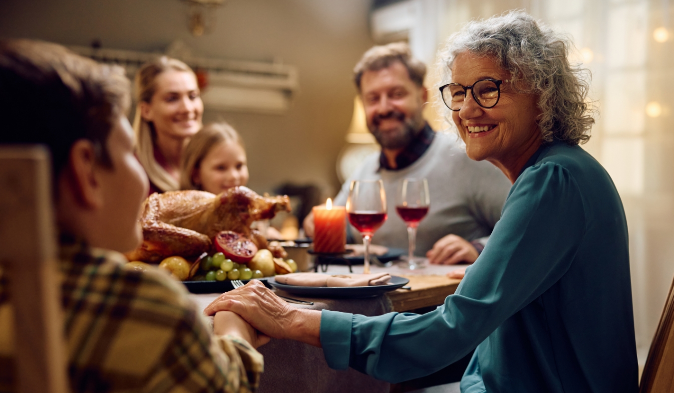 grandmother smiling at grandson at thanksgiving