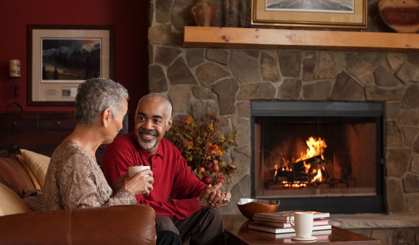 mature couple sitting by fireplace