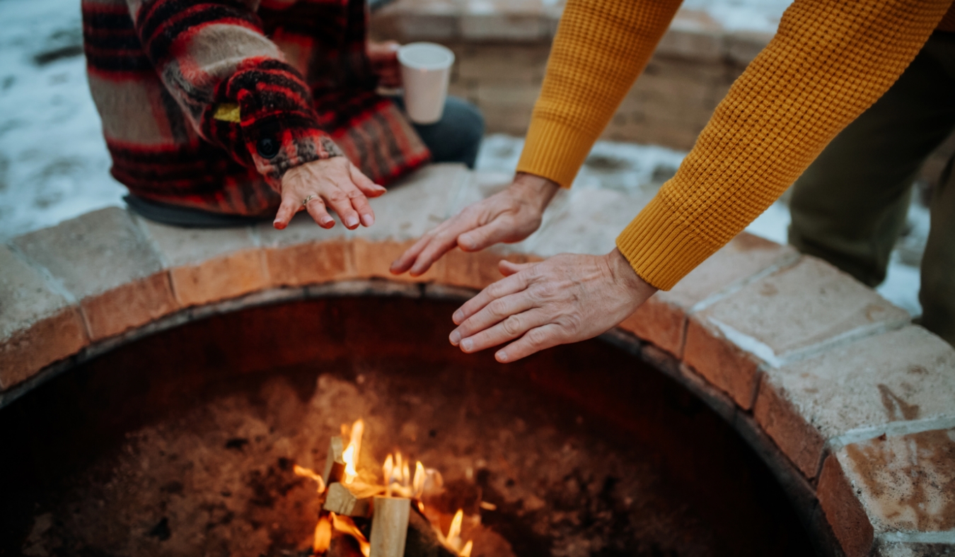 warming hands by an outdoor fire