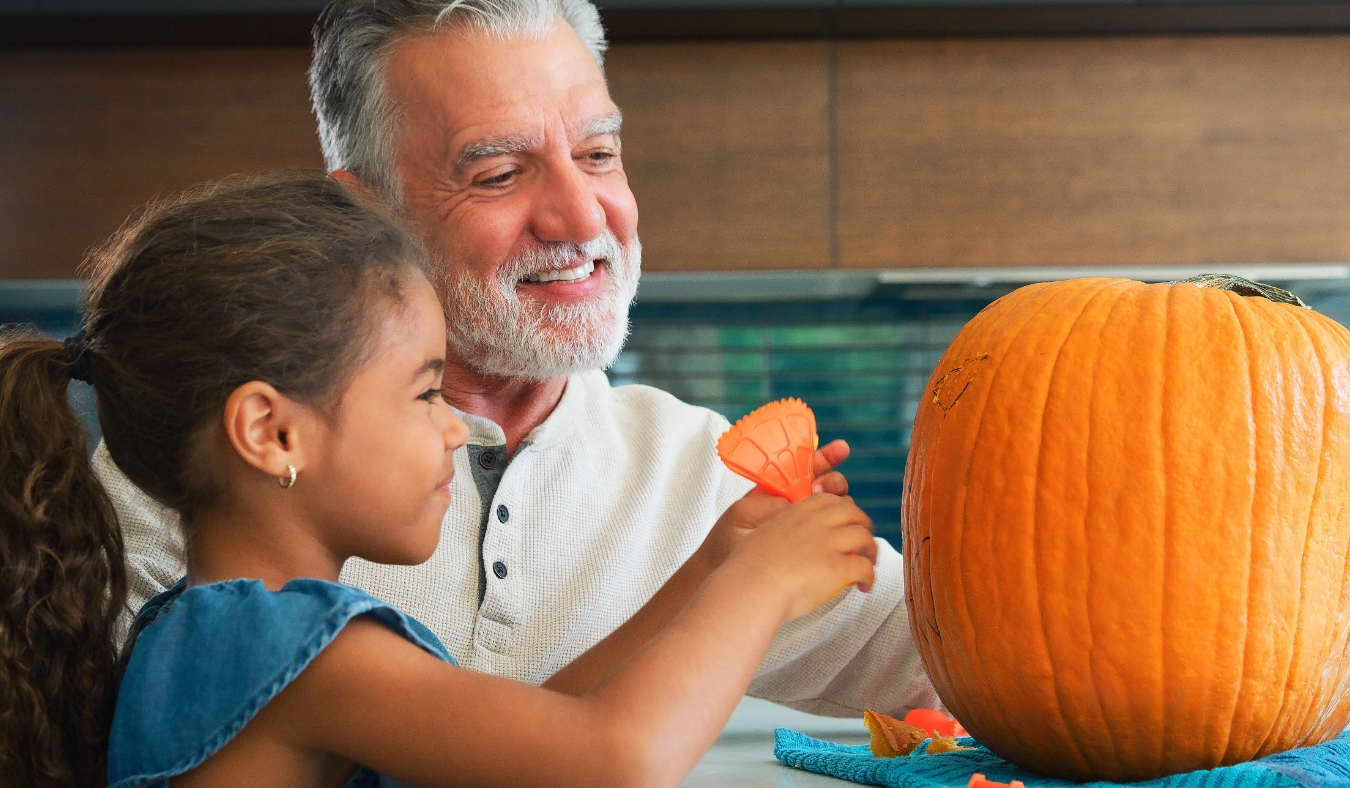 grandfather granddaughter carving pumpkins