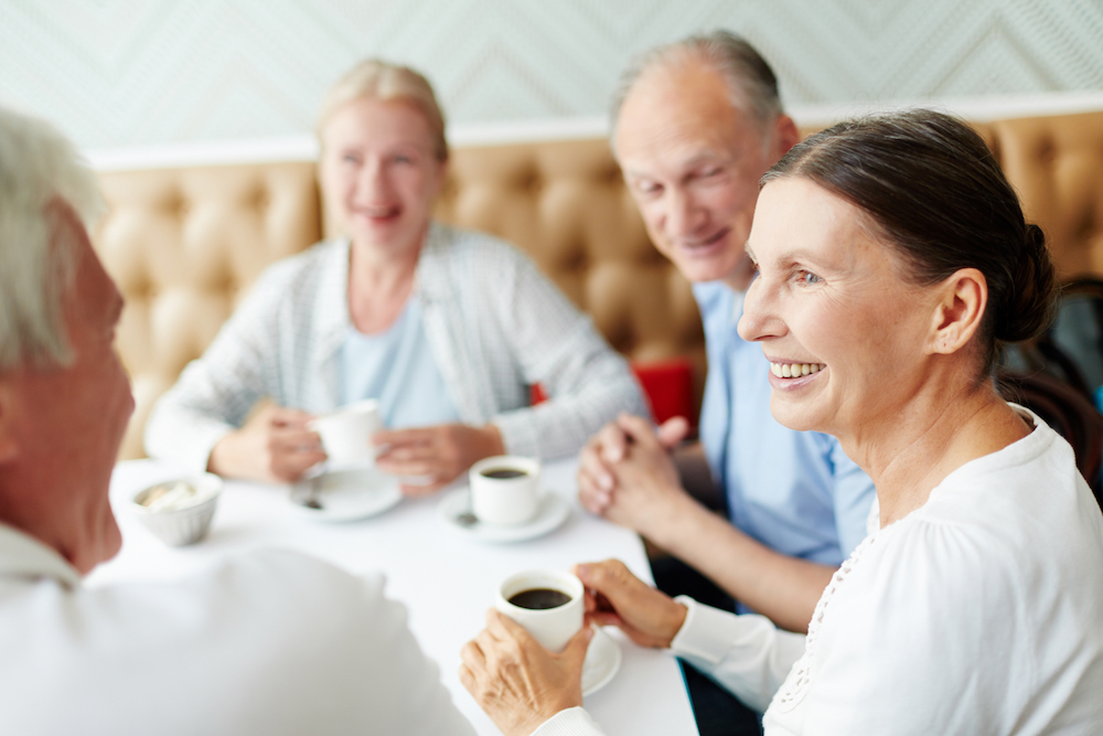four people drinking coffee in restaurant
