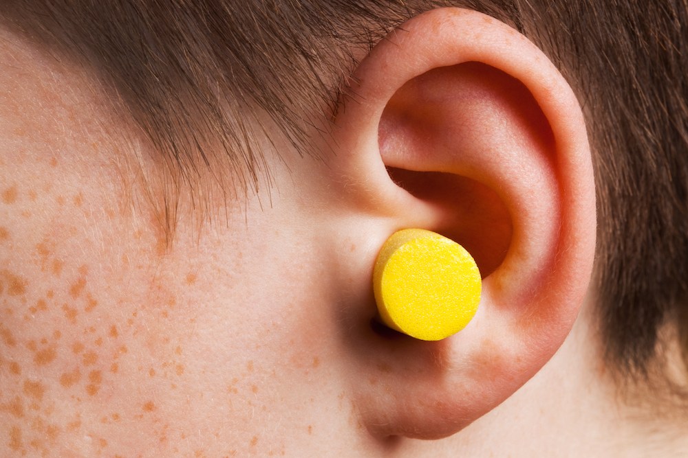 closeup of man wearing yellow earplugs