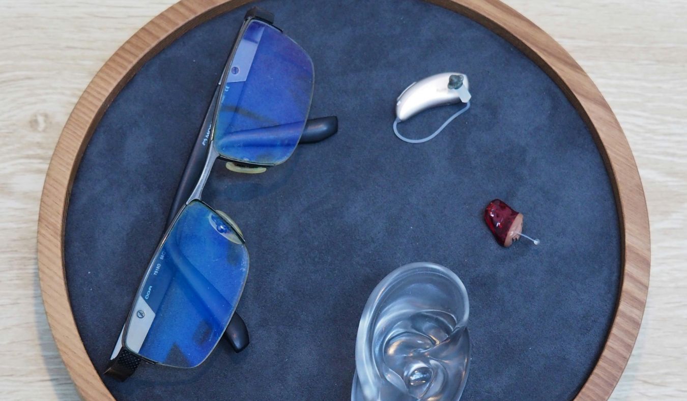 hearing solutions hearing aids on table next to ear model